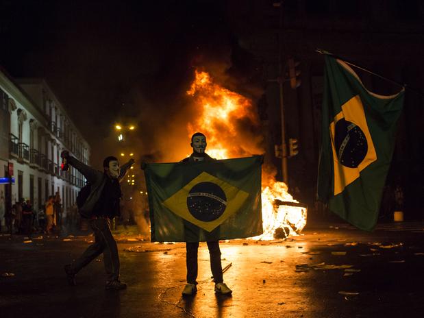Manifestantes atearam fogo em um carro próximo à Assembleia Legislativa do Rio. (Crédito: AP).