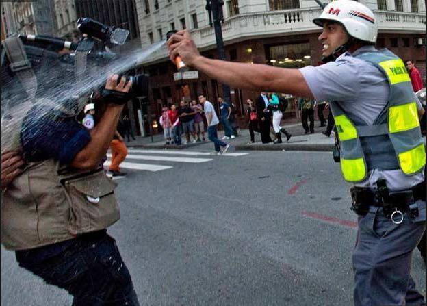 Flagrante de policial agredindo equipe de reportagem com spray de pimenta. (Crédito: Rodrigo Paiva/ Divulgação)
