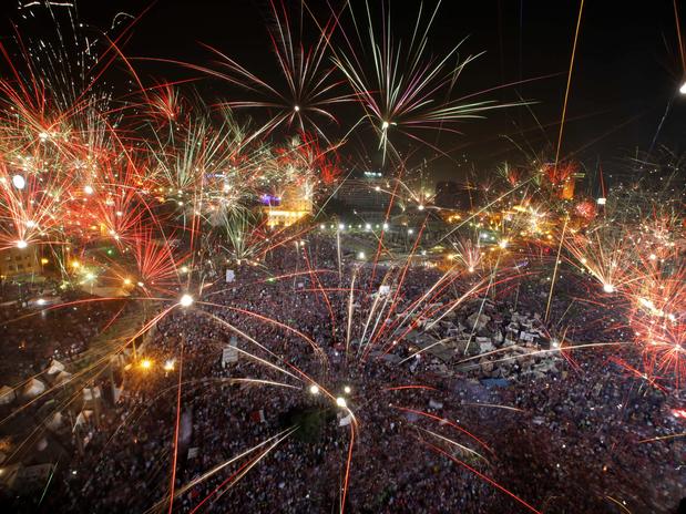 Fogos de artifício explodem sobre a praça Tahrir, no Cairo, após o anúncio da deposição do Presidente. Também houve manifestações pró-Mursi. (Crédito:AP)