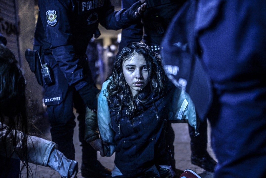 Imagem do turco Bulent Kilic mostra uma jovem ferida durante um confronto entre policiais e manifestantes (Crédito: Bulent Kilic/AFP)