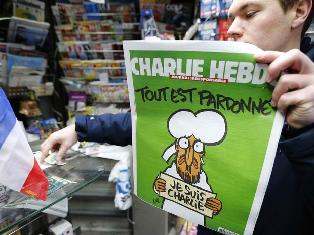 Homem mostra seu exemplar da 'edição dos sobreviventes' do 'Charlie Hebdo' após comprá-lo em uma banca de Paris (Foto: Stephane Mahe/Reuters)